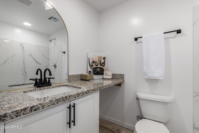 bathroom with vanity, wood-type flooring, toilet, and a shower