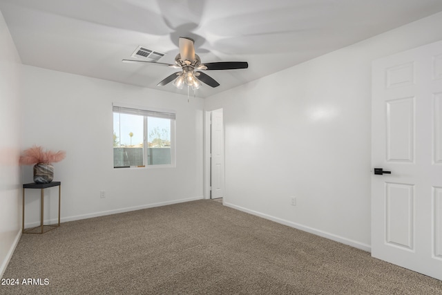 spare room featuring ceiling fan and carpet