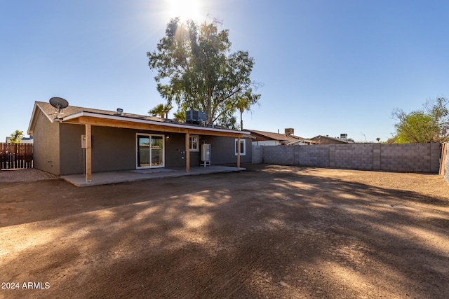 back of property with central AC unit and a patio area