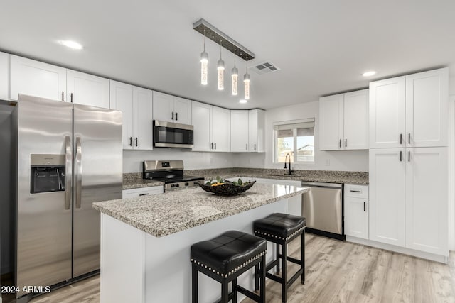 kitchen featuring sink, white cabinetry, a kitchen island, pendant lighting, and stainless steel appliances