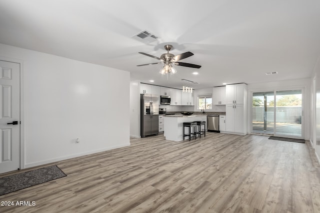 unfurnished living room featuring ceiling fan and light wood-type flooring