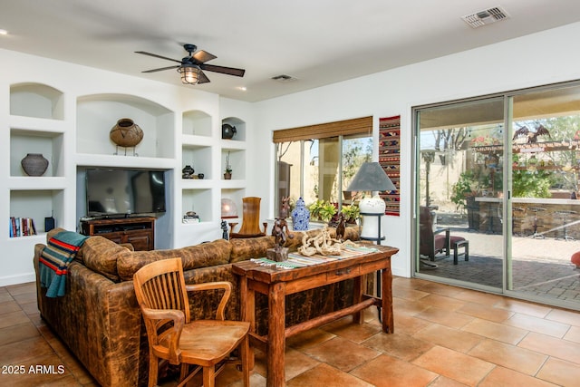 living room with ceiling fan and built in features