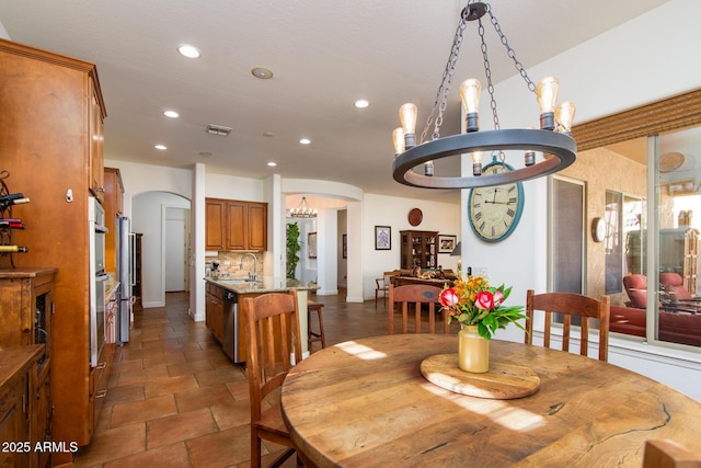 dining area featuring sink and an inviting chandelier