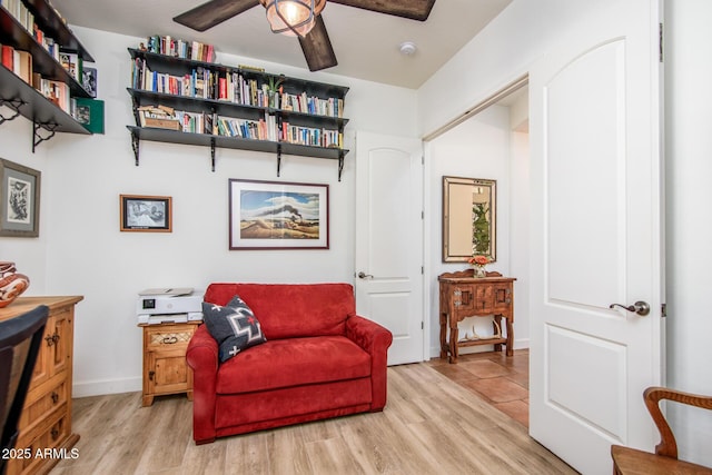 living area with ceiling fan and light hardwood / wood-style flooring