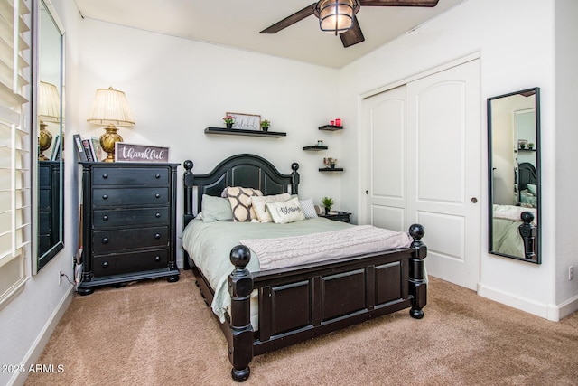 carpeted bedroom with ceiling fan and a closet