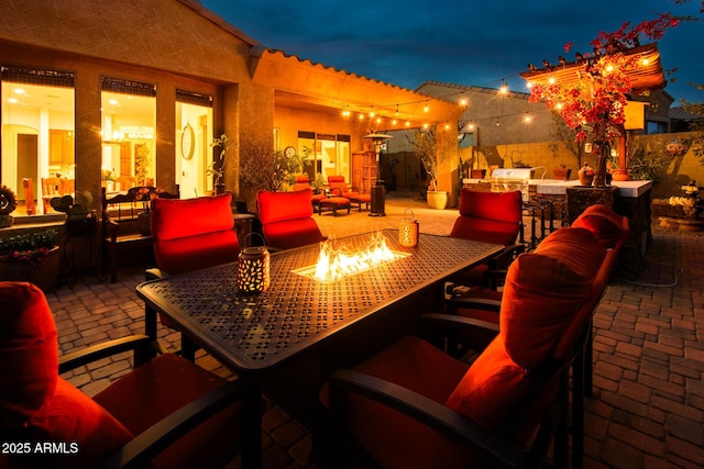 view of patio / terrace with exterior bar, an outdoor kitchen, and an outdoor fire pit