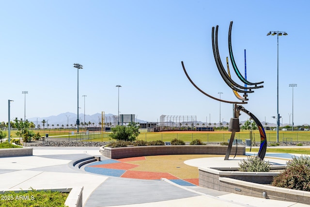 surrounding community with a mountain view and a lawn