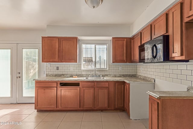 kitchen featuring backsplash, french doors, a healthy amount of sunlight, and sink