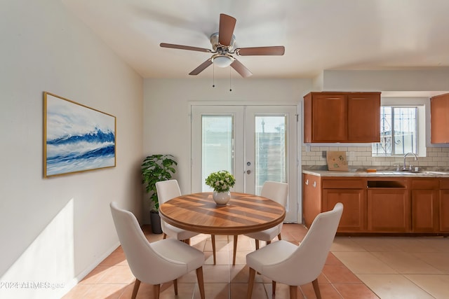 dining area with light tile patterned flooring, french doors, ceiling fan, and sink