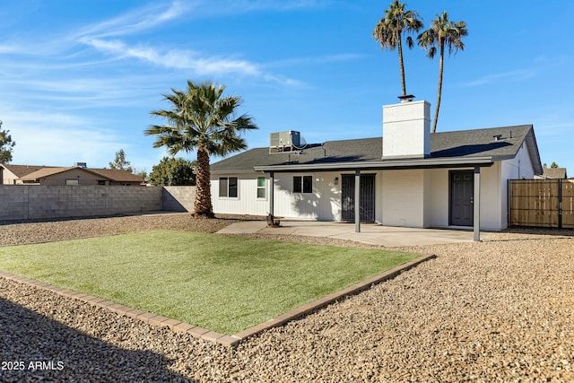 rear view of house with a patio and a yard