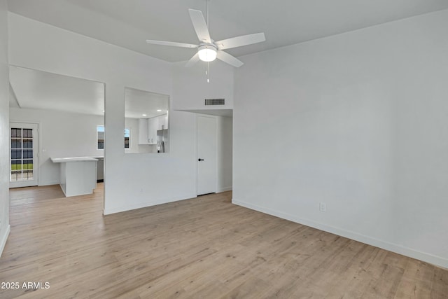 unfurnished living room featuring ceiling fan and light hardwood / wood-style flooring