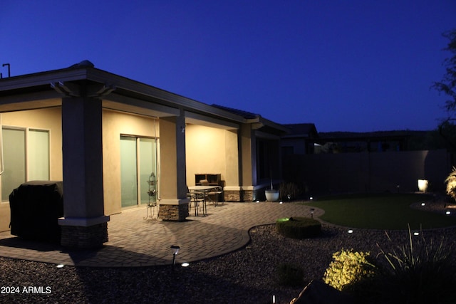 back house at twilight with a patio area