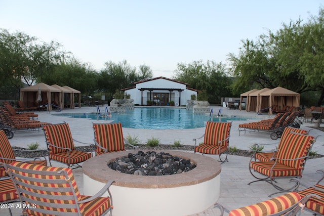 view of swimming pool with a fire pit, a gazebo, and a patio