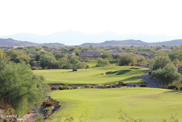 surrounding community with a mountain view and a yard