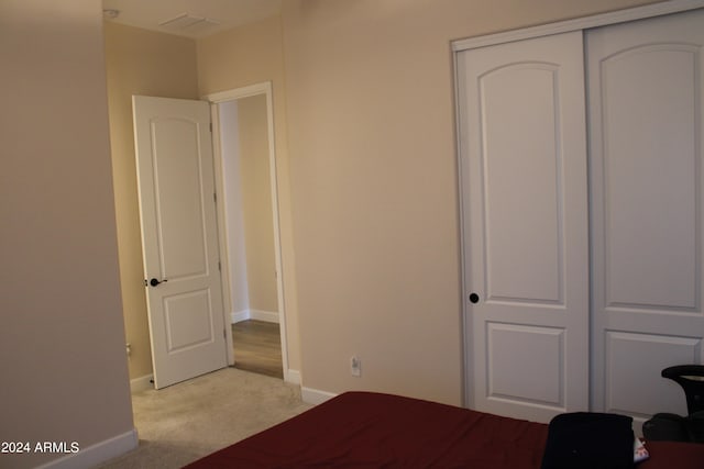 unfurnished bedroom featuring light carpet and a closet