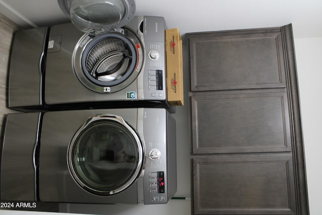 washroom featuring cabinets and stacked washer and dryer