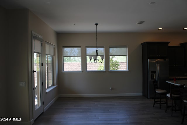 dining room with dark wood-type flooring and a chandelier