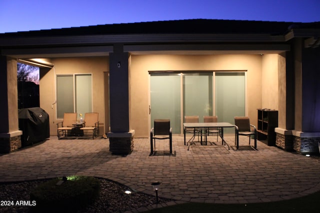 patio terrace at dusk featuring grilling area