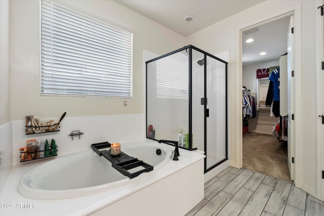 full bathroom with recessed lighting, wood finish floors, a shower stall, and a garden tub