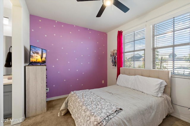 bedroom with an accent wall, baseboards, and carpet