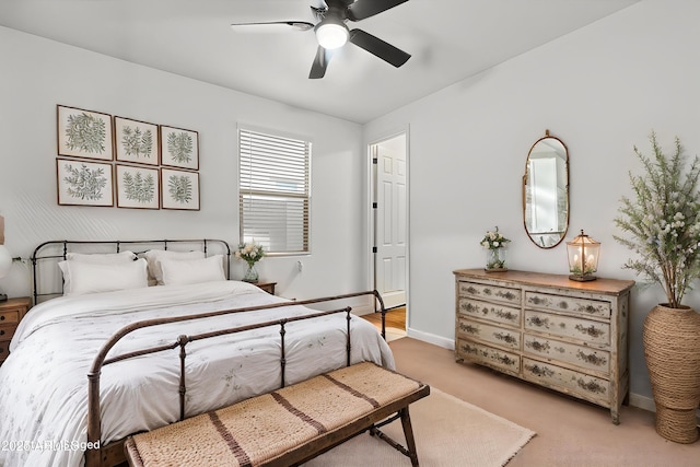 bedroom with light colored carpet, a ceiling fan, and baseboards