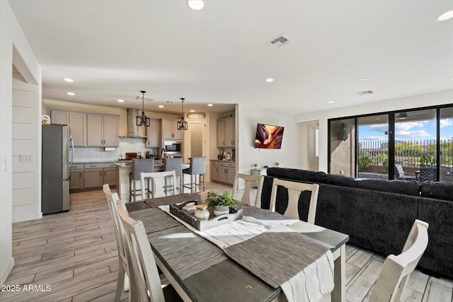 dining area with recessed lighting, light wood-style flooring, and visible vents
