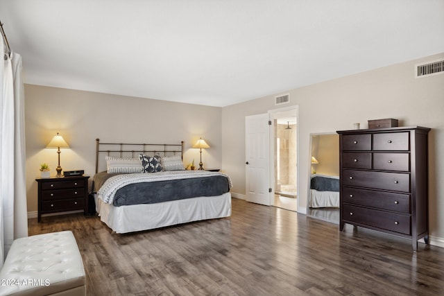 bedroom with connected bathroom and dark hardwood / wood-style floors