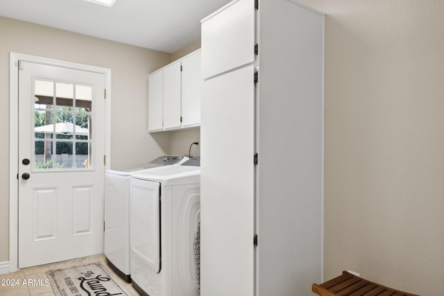 clothes washing area featuring washer and dryer and cabinets