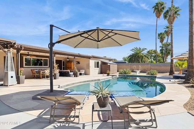 view of swimming pool featuring a patio and ceiling fan