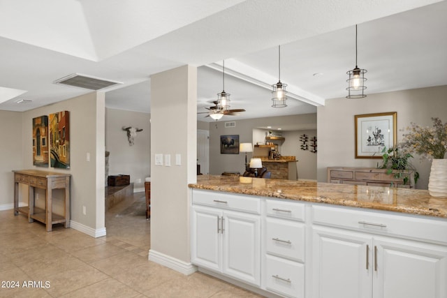 kitchen featuring ceiling fan, decorative light fixtures, light stone countertops, and white cabinets