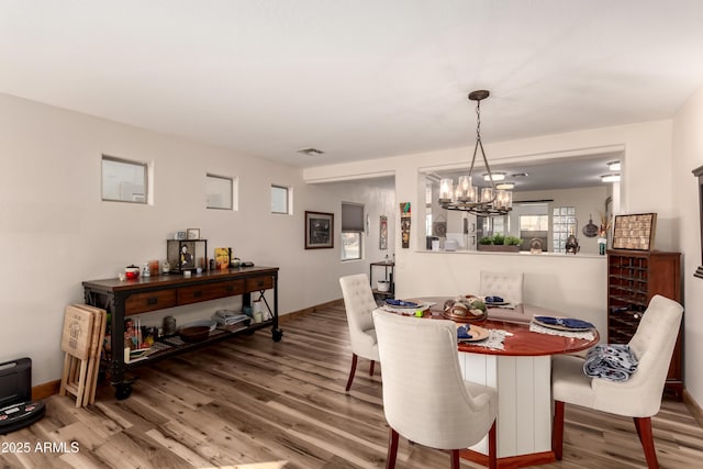 dining area featuring hardwood / wood-style flooring and a notable chandelier