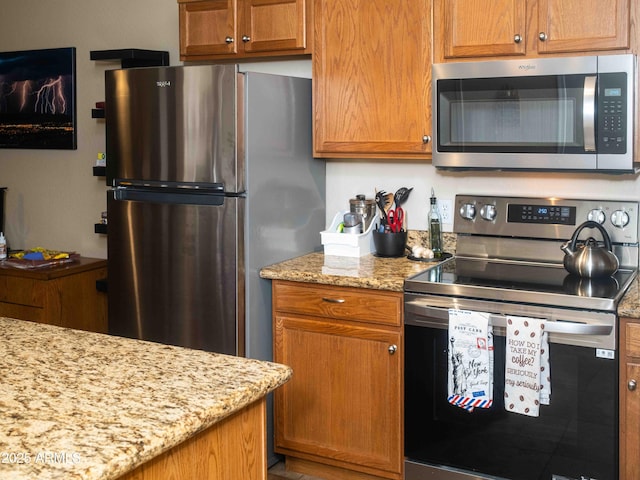 455 S Mesa Dr Unit 104, Mesa, AZ 85210 - kitchen with stainless steel appliances, light stone countertops, and brown cabinetry