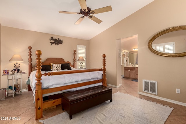 bedroom with ceiling fan, ensuite bath, light tile patterned floors, and vaulted ceiling