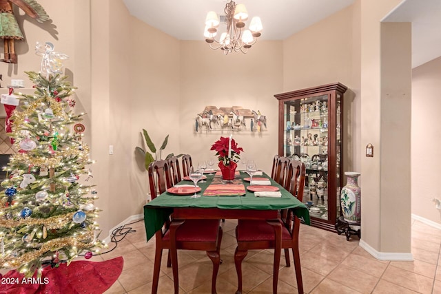 tiled dining room with a chandelier