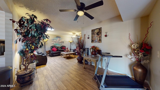 workout room with a textured ceiling, hardwood / wood-style flooring, and ceiling fan