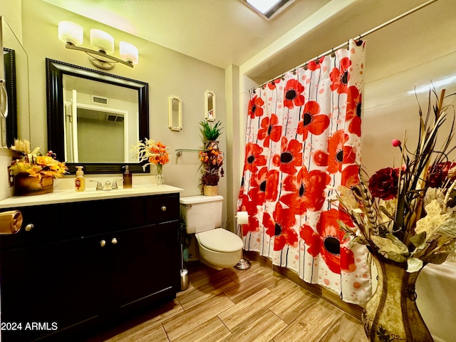 bathroom with walk in shower, vanity, toilet, and a textured ceiling