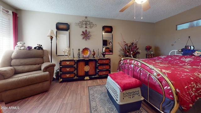 bedroom with hardwood / wood-style flooring, ceiling fan, and a textured ceiling