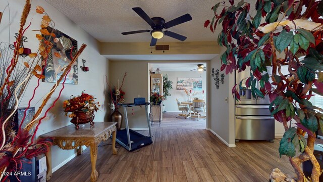 hallway with a textured ceiling and hardwood / wood-style flooring