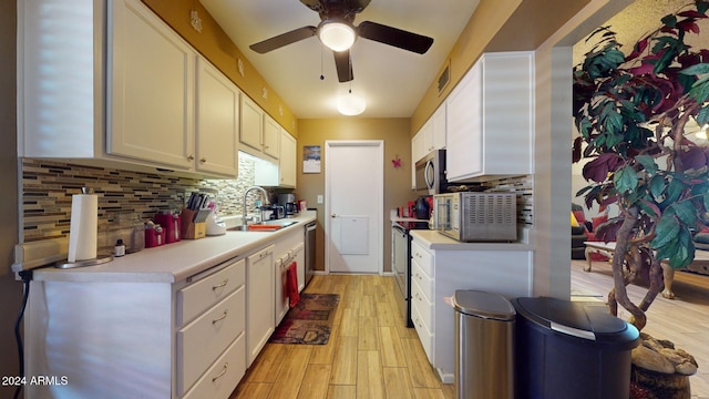 kitchen with appliances with stainless steel finishes, white cabinetry, sink, and decorative backsplash