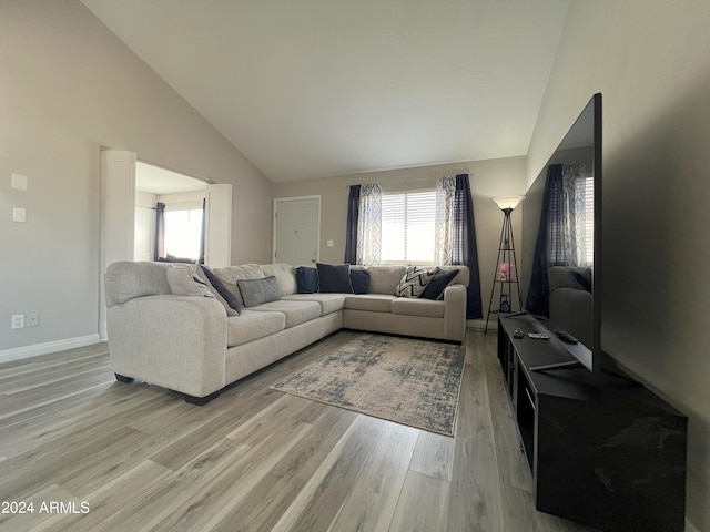 living room featuring high vaulted ceiling and light wood-type flooring