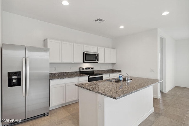 8474 W Clemente Way, Florence, AZ 85132 - kitchen with stainless steel appliances, a sink, dark stone counters, white cabinets, and recessed lighting