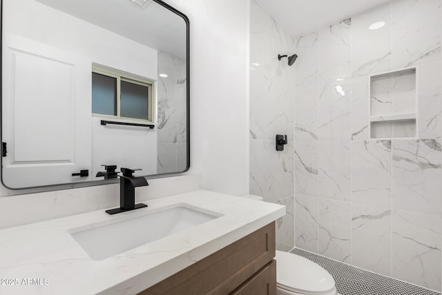 full bath with toilet, tiled shower, and vanity