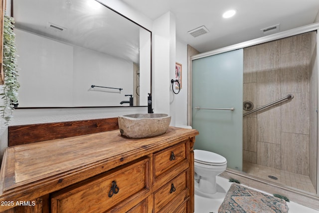 full bath with a stall shower, visible vents, vanity, and toilet