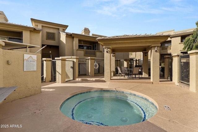 view of swimming pool with a community hot tub, a patio area, and fence