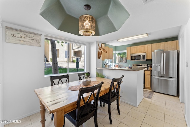 dining space featuring light tile patterned floors and baseboards