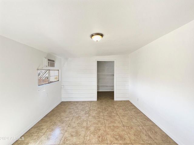 spare room with a wall mounted AC and lofted ceiling