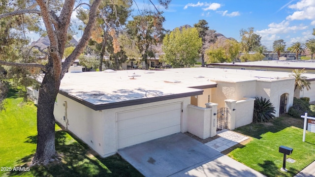 view of front of house with driveway, fence, a front lawn, and stucco siding