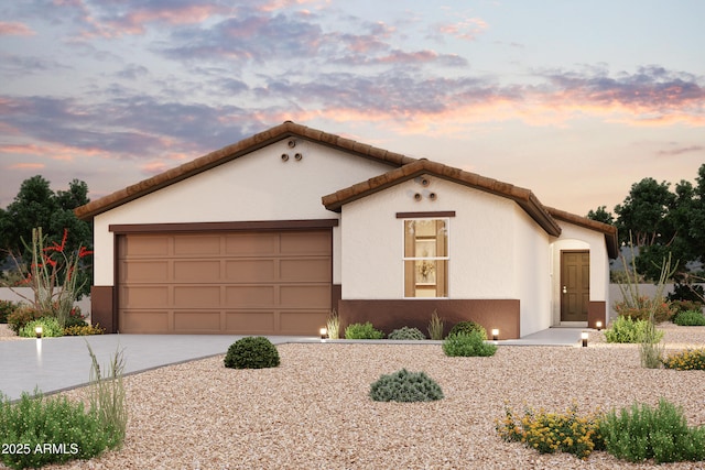 mediterranean / spanish house with a garage, concrete driveway, and stucco siding