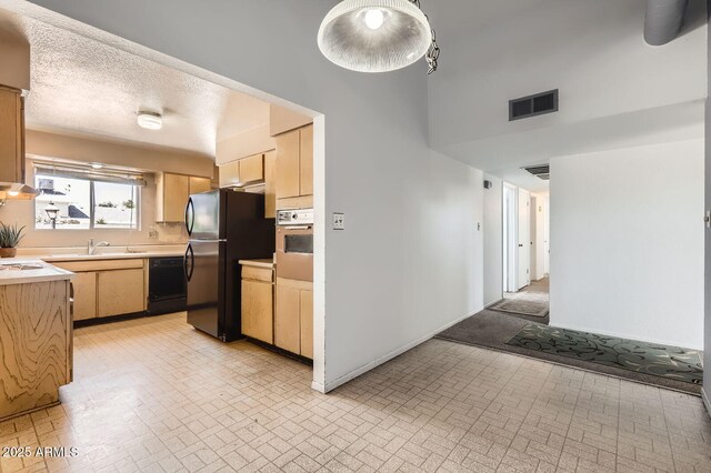 736 E Loyola Dr, Tempe, AZ 85282 - kitchen featuring black appliances, brick patterned flooring, light brown cabinetry, light countertops, and a towering ceiling