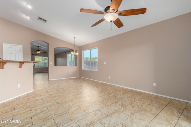 spare room with ceiling fan with notable chandelier and vaulted ceiling